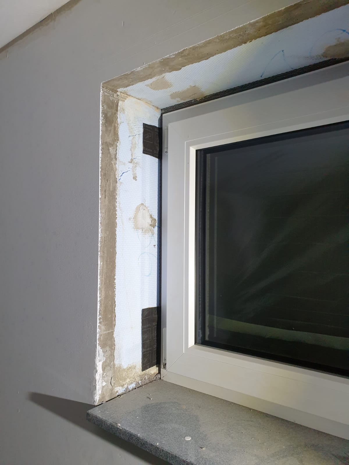 Fensterlaibung Keller mit Betonwand und Dämmung spachteln